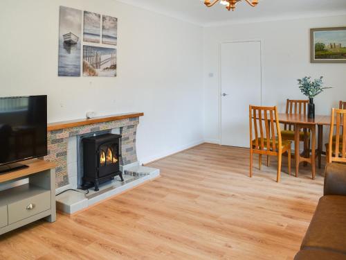a living room with a fireplace and a dining room table at Gwynfa in Rhyl
