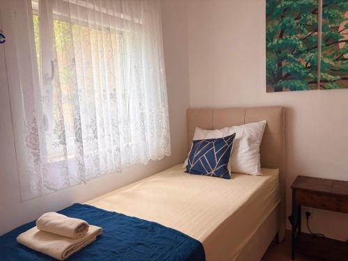 a small bedroom with a bed and a window at Apartment Feral in Neum