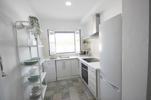 a white kitchen with a sink and a refrigerator at Casa Martina in Cádiz