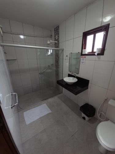 a bathroom with a shower and a sink and a toilet at Pousada Mirantes Do Sincorá in Mucugê