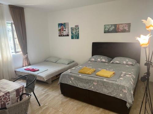 a bedroom with two beds and a table and a bed at Apartments Stuart in Utjeha
