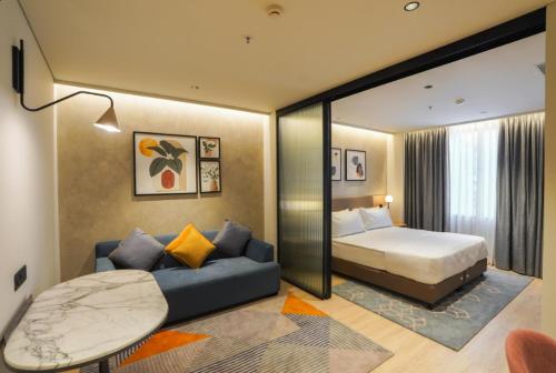a hotel room with a bed and a couch at The Canvas Loft-Manyata Tech Park-Orchid Parc in Bangalore