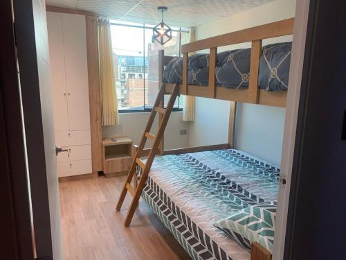 a bunk bed with a ladder in a room at Apartamentos WANCA SUITES para 4, 5 y 6 huéspedes cochera muy cerca al Centro in Huancayo