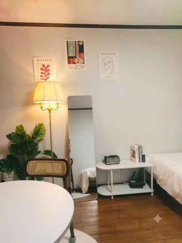 a room with a bed and a table and a lamp at Seoul Station condo in Seoul