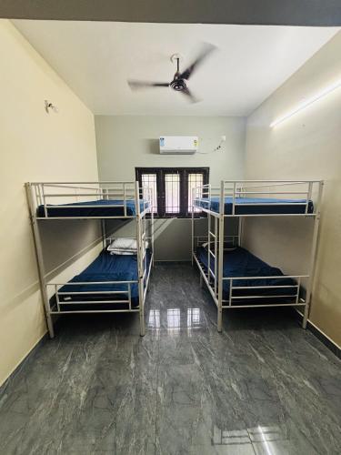 three bunk beds in a room with a ceiling at Sunrise Strength Club in Villupuram