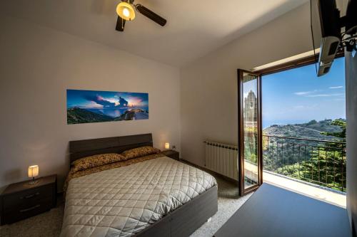 a bedroom with a bed and a large window at B&B Incantevole Vicolo in Piraino