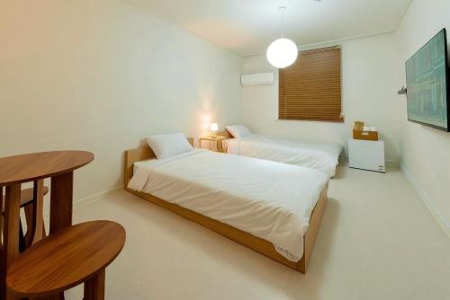 a small bedroom with two beds and a table at 브릭스테이 brikstay in Gyeongju