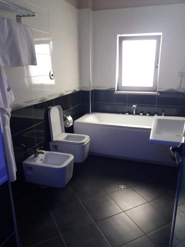 a bathroom with a tub and a toilet and a sink at Vila Ali Demi in Tirana