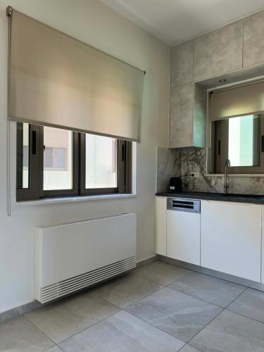 a kitchen with white cabinets and a sink and a mirror at Four Seasons Homes in Stalos