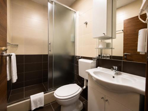 a bathroom with a toilet and a sink and a shower at Hotel Oaza in Konjic