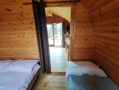a bedroom with two beds in a log cabin at Broomfields Glamping Pods in Whitby