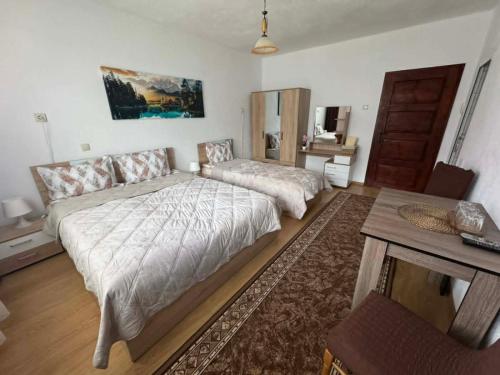 a bedroom with a large bed and a table at Къща за гости Здравец  in Trigrad
