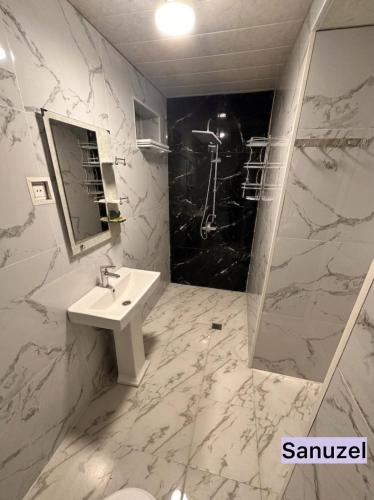 a white bathroom with a sink and a shower at Sheki Center Home in Sheki