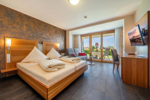 a hotel room with a bed and a television at Hotel Mohren in Hagnau