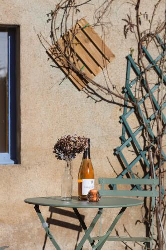 a table with a bottle of wine and flowers on it at B&B D'Issy in Issy-lʼÉvêque
