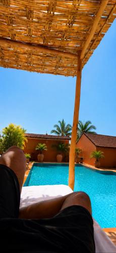 a person laying on a bed next to a swimming pool at Domaine JJ Marrakech in Marrakesh