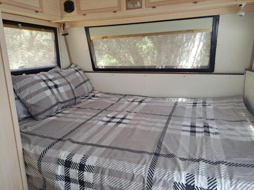 a bed in the back of an rv at Private caravan with mountain and sea view in Guájar-Faragüit