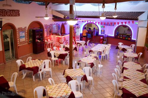 a restaurant with tables and chairs and people in the background at Camping Calabrisella in Borgia