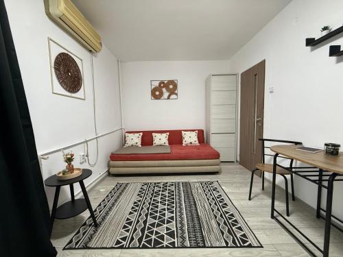 a living room with a red couch and a rug at Home Studio Arad in Arad