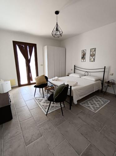 a bedroom with a bed and a table and chairs at Masseria Santa Laria in Borgagne