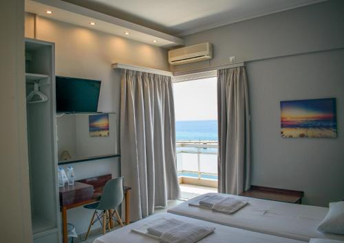 a hotel room with two beds and a window at Hotel ALS KARYSTOS in Karistos