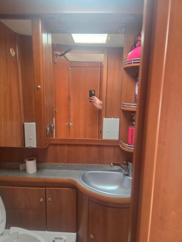 a person taking a picture of a sink in a bathroom at Tabber Trolltunga caravan in Odda