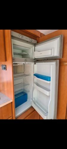 an empty refrigerator with its door open in a kitchen at Tabber Trolltunga caravan in Odda