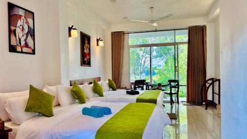 a bedroom with two beds with green and white pillows at Ella Pine Crest in Ella