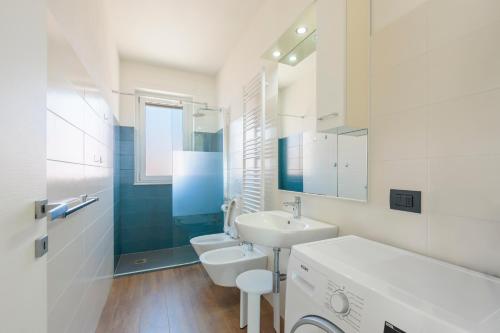 a white bathroom with a sink and a toilet at Appartamenti BluMare in Diano Marina