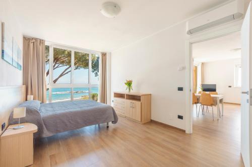 a bedroom with a bed and a view of the ocean at Appartamenti BluMare in Diano Marina