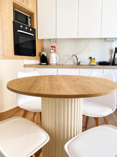 a kitchen with a wooden table and white cabinets at Bright and central apartment in Siátista