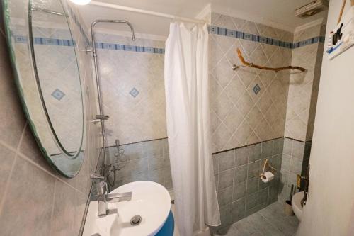 a bathroom with a shower and a sink and a toilet at Mania Rooms and Studios in Poros