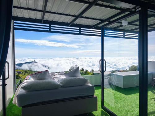 a bedroom with a view of the mountains through a window at Holiday view ภูทับเบิก in Ban Maeo Thap Boek