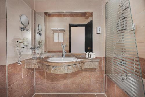 ein Badezimmer mit Waschbecken und Spiegel in der Unterkunft Holidays Express Hotel Cairo in Kairo