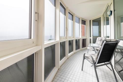 a balcony with chairs and windows in a building at Gemütliche Ferienwohnung mit Wintergarten & Meerblick am Südstrand Wohnung 123 in Wilhelmshaven