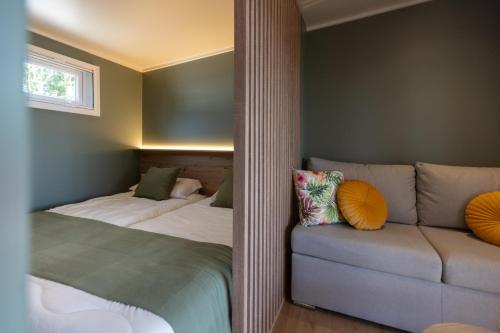 a bedroom with two beds and a couch at Camping As Cancelas in Santiago de Compostela