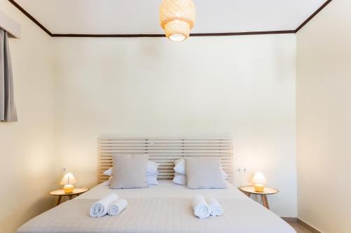 a bedroom with a bed with two white towels on it at Cavo Plako Villas in Palekastron