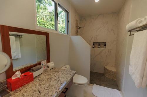 a bathroom with a sink and a toilet and a mirror at Hotel Las Lomas in Nandayure