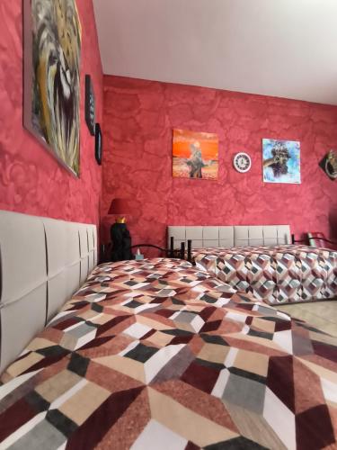 a bedroom with a large bed with a red wall at L'armadio di Narni -A in Narni