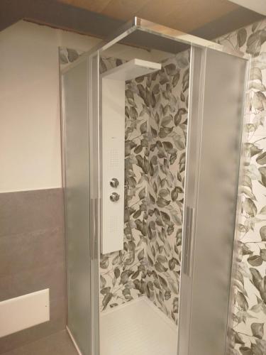 a shower stall with a floral pattern on the wall at L'Elefantino - Bed and Book in Roccasparvera