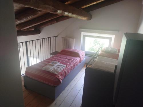 a bedroom with two beds and a window at L'Elefantino - Bed and Book in Roccasparvera