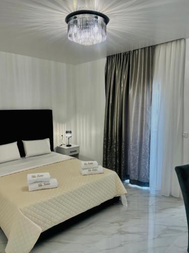 a bedroom with a bed and a chandelier at Villa Koćuša in Ljubuški