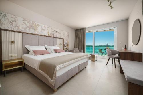 a bedroom with a bed and a view of the ocean at Hotel Duje in Vodice