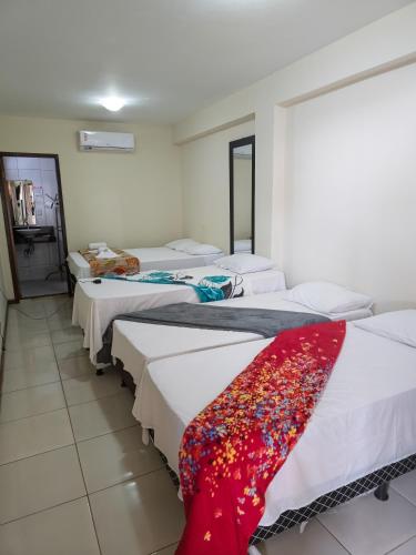 a room with four beds with a red blanket on them at Pousada Mirantes Do Sincorá in Mucugê