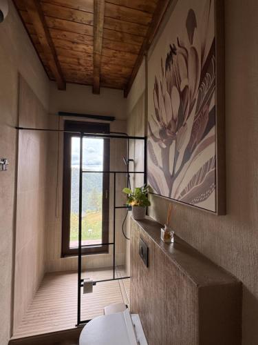 a bathroom with a toilet and a large painting on the wall at Nordik Crest in Mărişel