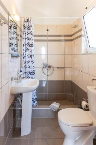 a bathroom with a sink and a toilet and a shower at Cavo Plako Villas in Palekastron