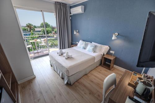 a bedroom with a bed and a large window at Hotel Boutique La Brisa in Vilanova i la Geltrú