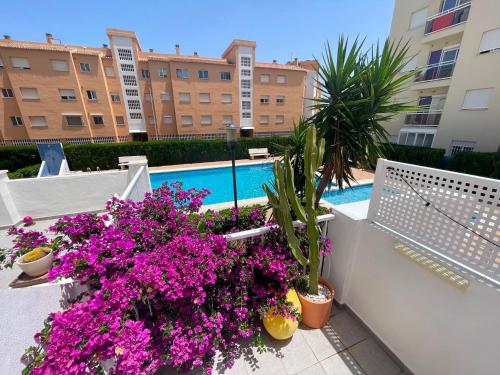 a balcony with flowers and a swimming pool at Casa cactus Piles Playa in Piles