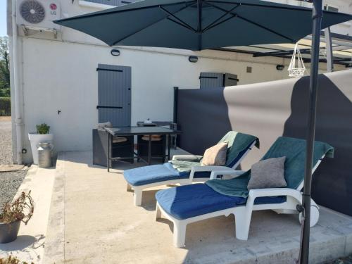 a patio with two chairs and an umbrella at La Trimouillaise in La Trimouille