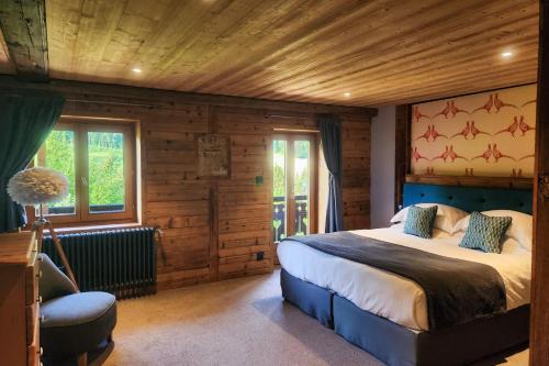 a bedroom with a large bed in a log cabin at Chalet Cannelle in Châtel